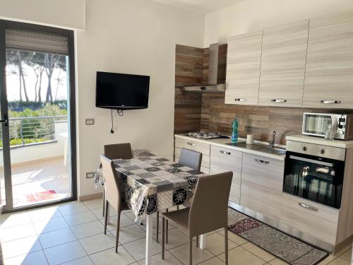 a kitchen with a table and chairs and a television at Trilocale Fronte Mare Pineto in Pineto