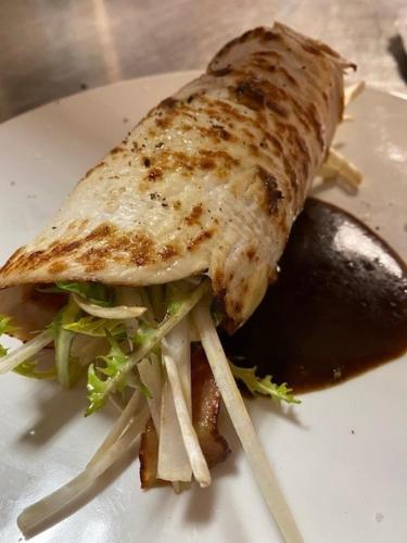 a sandwich on a white plate with a pickle at Logis Hôtel-Restaurant du Herrenstein in Neuwiller-lès-Saverne