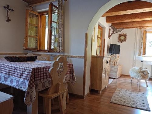 ein Esszimmer mit einem Tisch und einem Fenster in der Unterkunft Chata Smrek a kontaktná MINI ZOO in Jezersko