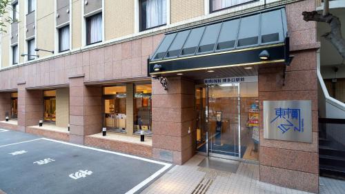 una tienda frente a un edificio en una calle de la ciudad en Toyoko Inn Hakata-guchi Ekimae, en Fukuoka