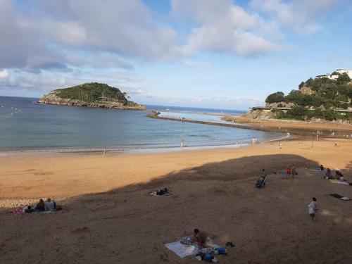 a group of people on a beach with the ocean at La casa de Arantza con jardin y wifi in Ispáster