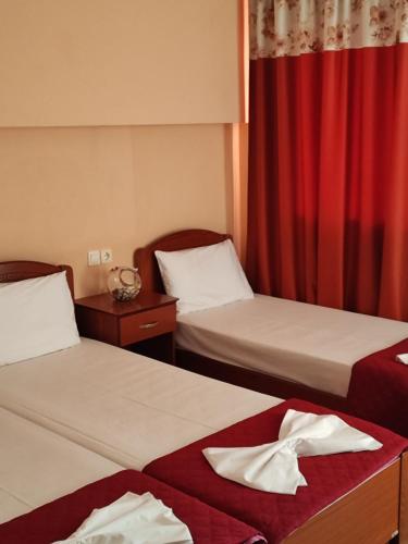 a hotel room with two beds and a red curtain at SMILE in Platamonas