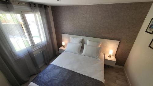 1 dormitorio con 1 cama blanca y 2 lámparas en La TISSONNIERE Mer Alpilles Provence et Luberon avec Spa et Piscine à 10mns d Aix en Provence, en Saint-Estève-Janson