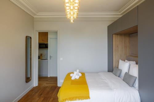 une chambre avec un grand lit avec une couverture jaune dans l'établissement The Eiffel Tower Cosy Nest, à Paris