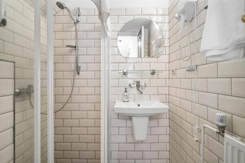 a white bathroom with a sink and a shower at Pension Regina in Český Krumlov