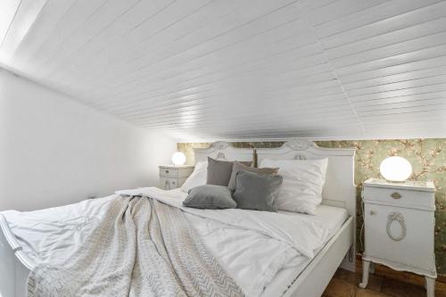 a white bed in a room with a white ceiling at Pension Regina in Český Krumlov