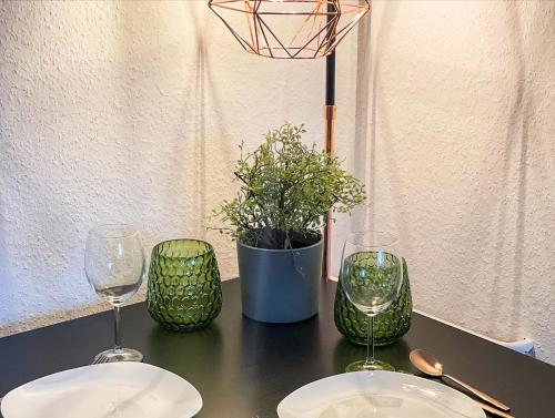 a table with two wine glasses and a potted plant at Apartment für 3 Gäste kostenlose Parkplätze und Lift in Hannover
