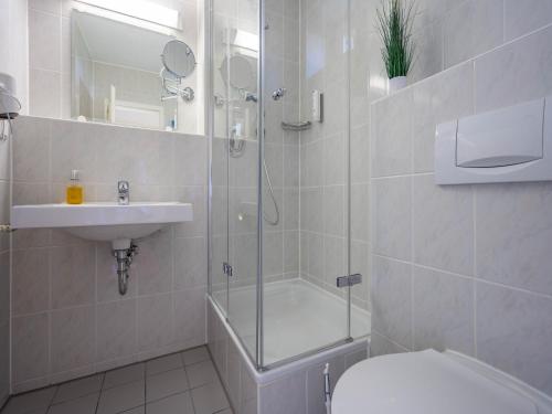 une salle de bains avec douche, toilettes et lavabo dans l'établissement Feriendorf Rugana - Klassik 1-Raum Appartement mit Terrasse B32, à Dranske
