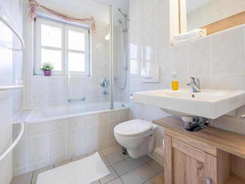 ein weißes Badezimmer mit Waschbecken und Toilette in der Unterkunft Feriendorf Rugana - Komfort Appartement mit 2 Schlafzimmern und Terrasse C48 in Dranske