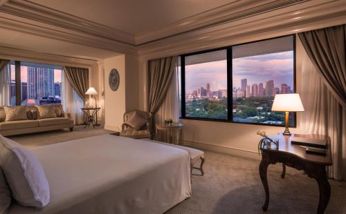 a hotel room with a bed and a large window at The Peninsula Manila in Manila