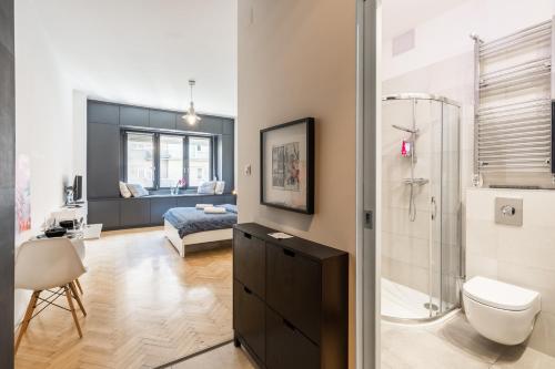 a bathroom with a shower and a toilet and a bedroom at Bright studio apartment with a gorgeus Parliament in Budapest