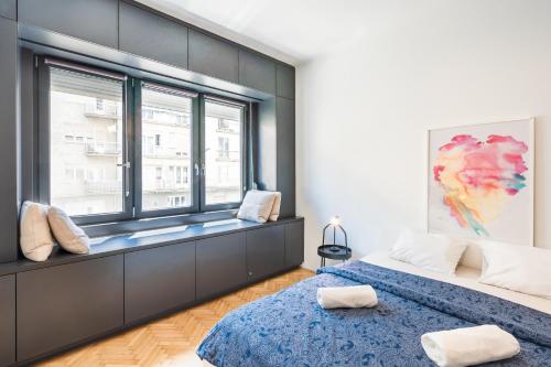 1 dormitorio con 2 camas y ventana en Bright studio apartment with a gorgeus Parliament, en Budapest