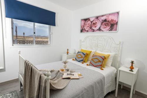 a bedroom with a bed with a table and a window at Apartamento San Valentin in Corralejo