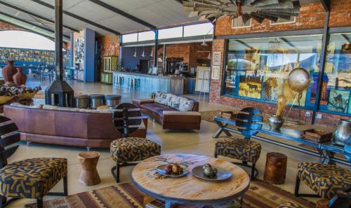 a lobby with a table and chairs and a bar at Okonjima Plains Camp in Otjiwarongo