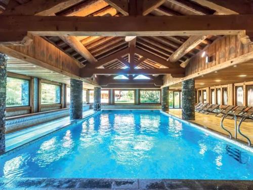 une grande piscine avec un plafond en bois dans l'établissement Appartement 4 pers avec piscine commune Carroz d'Araches, aux Carroz d'Arâches