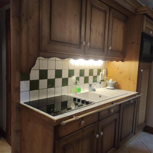 Il dispose d'une cuisine avec un évier et un mur carrelé. dans l'établissement Appartement 4 pers avec piscine commune Carroz d'Araches, aux Carroz d'Arâches