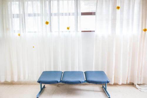 two blue chairs in front of a window with curtains at HI Hostel Dubrovnik in Dubrovnik