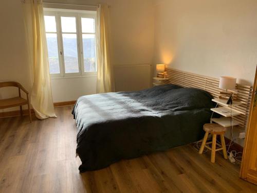 a bedroom with a large bed and a window at Les chambres de la Bastide in Saint-Sauveur-de-Montagut