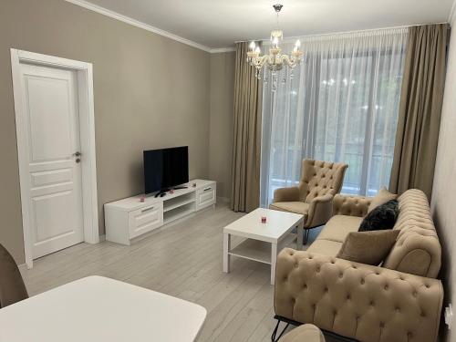 uma sala de estar com um sofá e uma televisão em DELUXE APARTAMENTS DARIS em Kazanlŭk