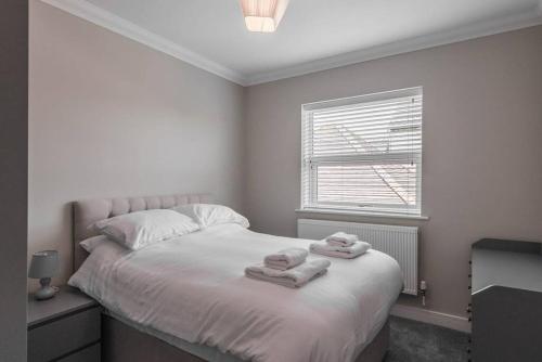 a bedroom with a bed with towels on it at Gillian House - Charming Broadstairs apartment in Kent