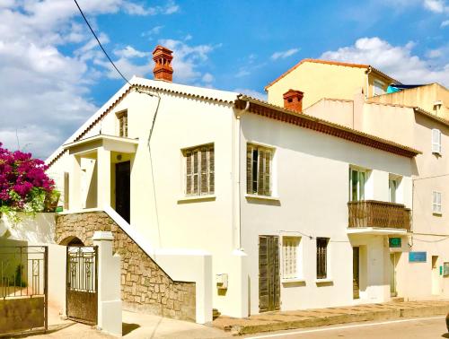a white house on a street at CASA MONICA CARGESE - Roseroom - Chambre d hote in Cargèse