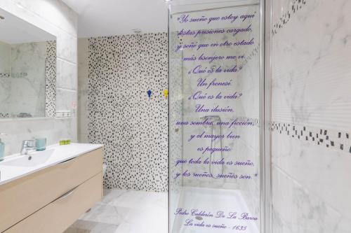 a bathroom with purple writing on the shower curtain at Apartamento La Alegria de Córdoba Centro in Córdoba