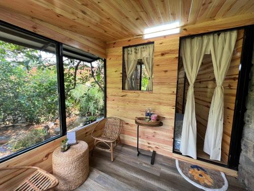 HomeTa Homestay في باو لوك: غرفة بجدران خشبية ونوافذ كبيرة