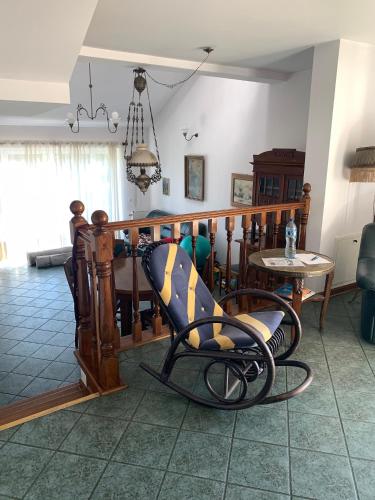 a living room with a chair and a table at Willa 250 M z basenem, jacuzzi, ogrodem , tarasem oraz 2 hektary sadu , kominek i inne atrakcje in Buszkowice