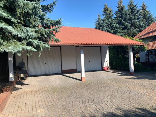 a building with an orange roof and a brick driveway at Willa 250 M z basenem, jacuzzi, ogrodem , tarasem oraz 2 hektary sadu , kominek i inne atrakcje in Buszkowice