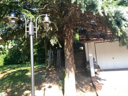 a street light next to a tree and a garage at Willa 250 M z basenem, jacuzzi, ogrodem , tarasem oraz 2 hektary sadu , kominek i inne atrakcje in Buszkowice