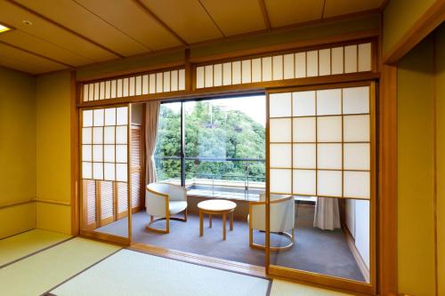 a room with a window and a table and chairs at Kinzan in Kobe