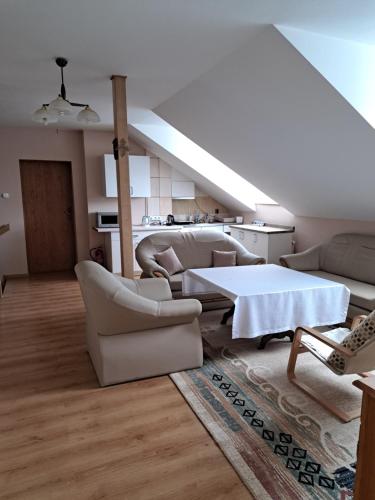 a living room with white furniture and a white table at U Eskulapa in Lutowiska
