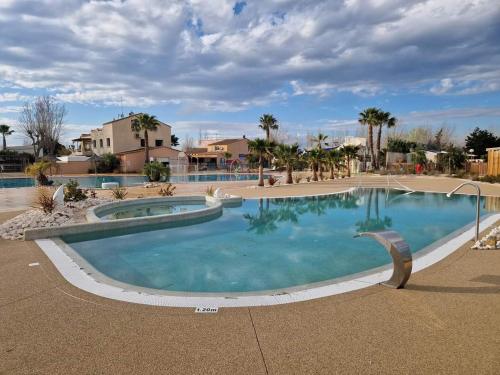 a large swimming pool in a resort at Le Cosy, mobil-home 4-6 personnes au camping les Sables du Midi à Valras-Plage in Valras-Plage