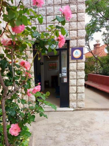 a building with pink flowers in front of a door at HI Hostel Dubrovnik in Dubrovnik