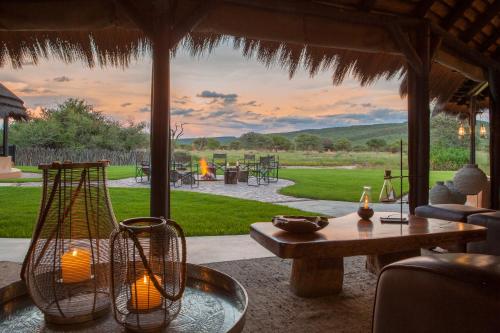 奧奇瓦龍戈的住宿－Okonjima Luxury Bush Camp，客厅配有桌子和雨伞