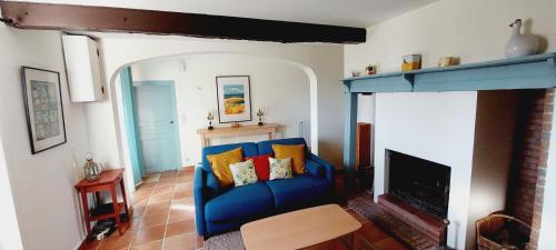 a living room with a blue couch and a fireplace at Les Gites de Campardon 