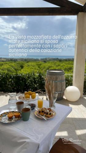 a table with plates of food and drinks on it at Agriturismo Alle Riserve Cavagrande in Avola