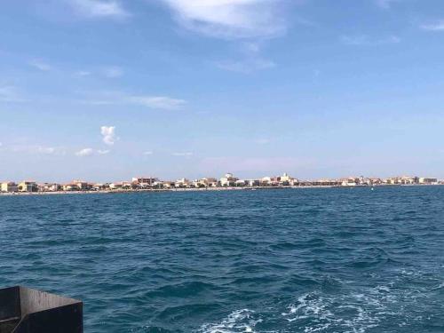 a large body of water with a city in the background at T2 neuf + piscine, 5 mn à pied des plages in Sérignan