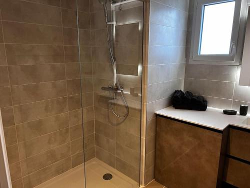 a shower with a glass door in a bathroom at T2 neuf + piscine, 5 mn à pied des plages in Sérignan