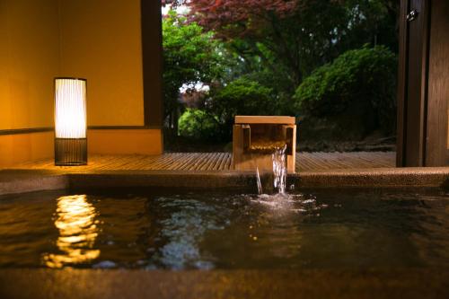 uma fonte no meio de uma piscina de água em Bettei Haruki em Beppu