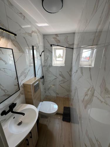 a white bathroom with a sink and a mirror at Antylia1 in Władysławowo