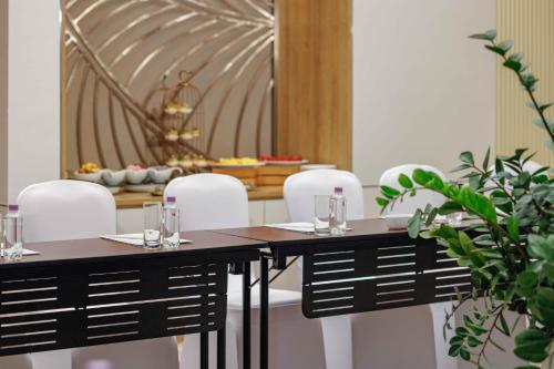 a dining room with a table and white chairs at Wyndham Garden Cam Ranh Resort in Cam Ranh