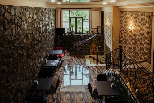 a restaurant with tables and chairs and a stone wall at Rafting House in Odzun