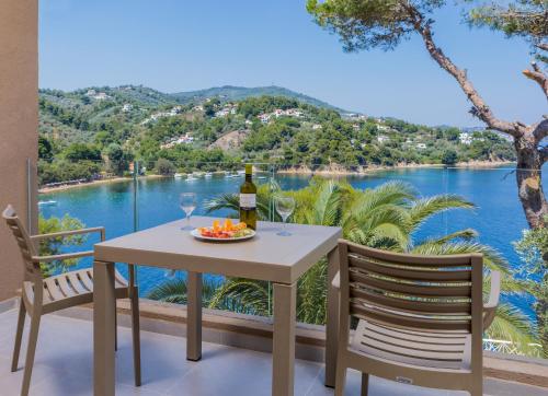 a table with a bottle of wine and two chairs at Cape Kanapitsa Hotel & Suites in Kanapitsa