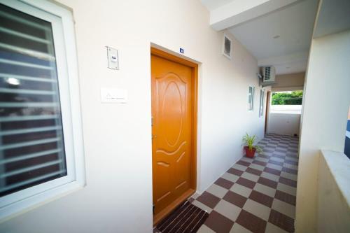 pasillo con puerta marrón y suelo a cuadros en KUKAL CASTLE, en Tirupur