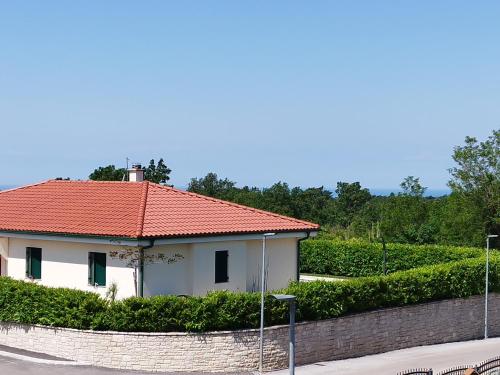 Casa blanca con techo rojo y pared en ToniS, en Buje