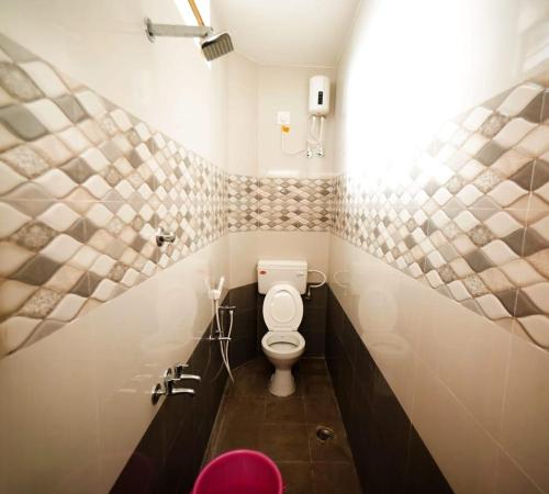 baño con aseo blanco en una habitación en KUKAL CASTLE, en Tirupur