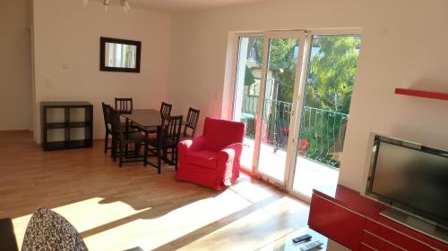 a living room with a red chair and a table and a television at Apartment Vindobona in Vienna