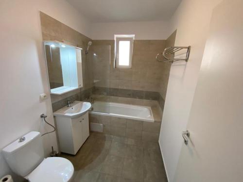a bathroom with a toilet and a tub and a sink at Gaga Residence 15 in Timişoara