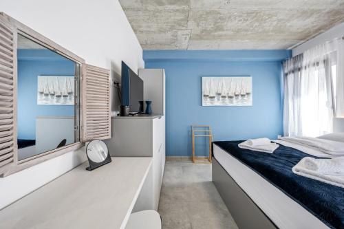Schlafzimmer mit blauen Wänden und einem Bett mit Spiegel in der Unterkunft theTinel in Zaboric